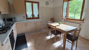 A compact kitchen with a microwave, stove, and dining table with chairs.