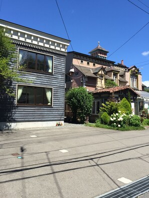 A residential street with houses featuring traditional architecture, including a two-story building with large windows and a sloped roof. - Auberge Booz Annex (Yamanakako)