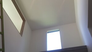 A room with a sloped ceiling, a skylight, and a window. - Auberge Booz Annex (Yamanakako)
