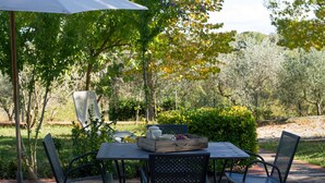 An outdoor patio with a table, chairs, and a white umbrella. - WINDMILL apartment with private terrace (Empoli)