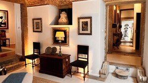 A room with a stone ceiling, a wooden cabinet, a lamp, and framed pictures on the wall. - Spirit of 1512 - Exquisite taste in the heart of Alfama (Lisboa)