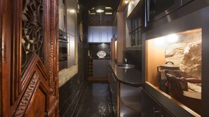 A narrow hallway with a tiled floor, wooden door with intricate carvings, and a stone wall with a small window. - Spirit of 1512 - Exquisite taste in the heart of Alfama (Lisboa)