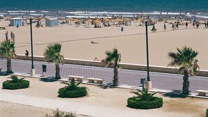 A beach with people, umbrellas, and palm trees. - Fast-E WiFi/On-St parking/Metro Hub @290m/Cafe Society Enclave. (Valencia)