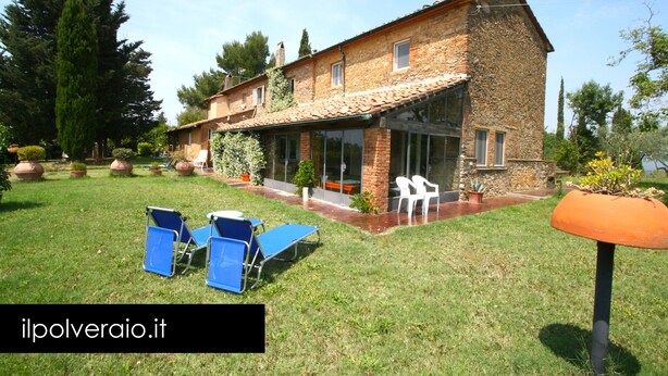 A two-story house with a garden and outdoor seating area.