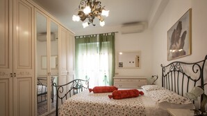 A bedroom with a bed, a nightstand, a dresser, a mirror, and a chandelier. - Apartment “La Primavera holidayhouse” center Rome 100 m from Vatican Free Wifi (Roma)