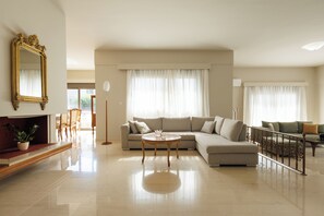 A spacious living room with a large sofa, a coffee table, and a fireplace.