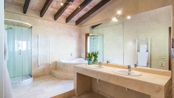 Een bad/douchecombinatie, een bubbelbad, een haardroger, een bidet