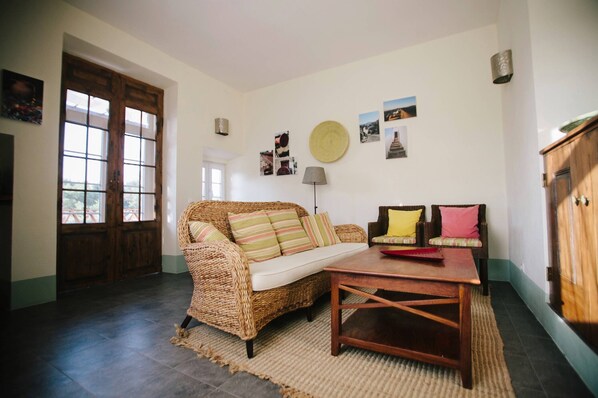 A cozy living room with a wicker sofa, a wooden coffee table, and a small rug.