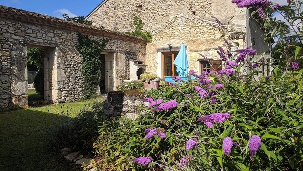 Un edificio de piedra con un jardín delantero.