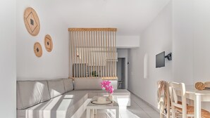 Una sala de estar moderna con un sofá, una mesa de centro y un comedor con sillas.