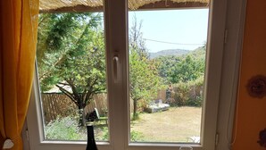 Un comedor con una mesa dispuesta para dos personas, que incluye una botella de vino, copas y platos.