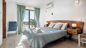 A bedroom with a bed, nightstands, a chair, and a window with curtains. - Villa Susana ~ Heated Pool* ~ Fast Wi-fi ~ 6 + 4 cots - Booking 2027 & 2028 NOW! (Sao Bartolomeu de Messines)