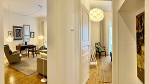 Un salon moderne comprenant un canapé, des fauteuils, une table basse et une table à manger. Un escalier mène à un autre niveau.