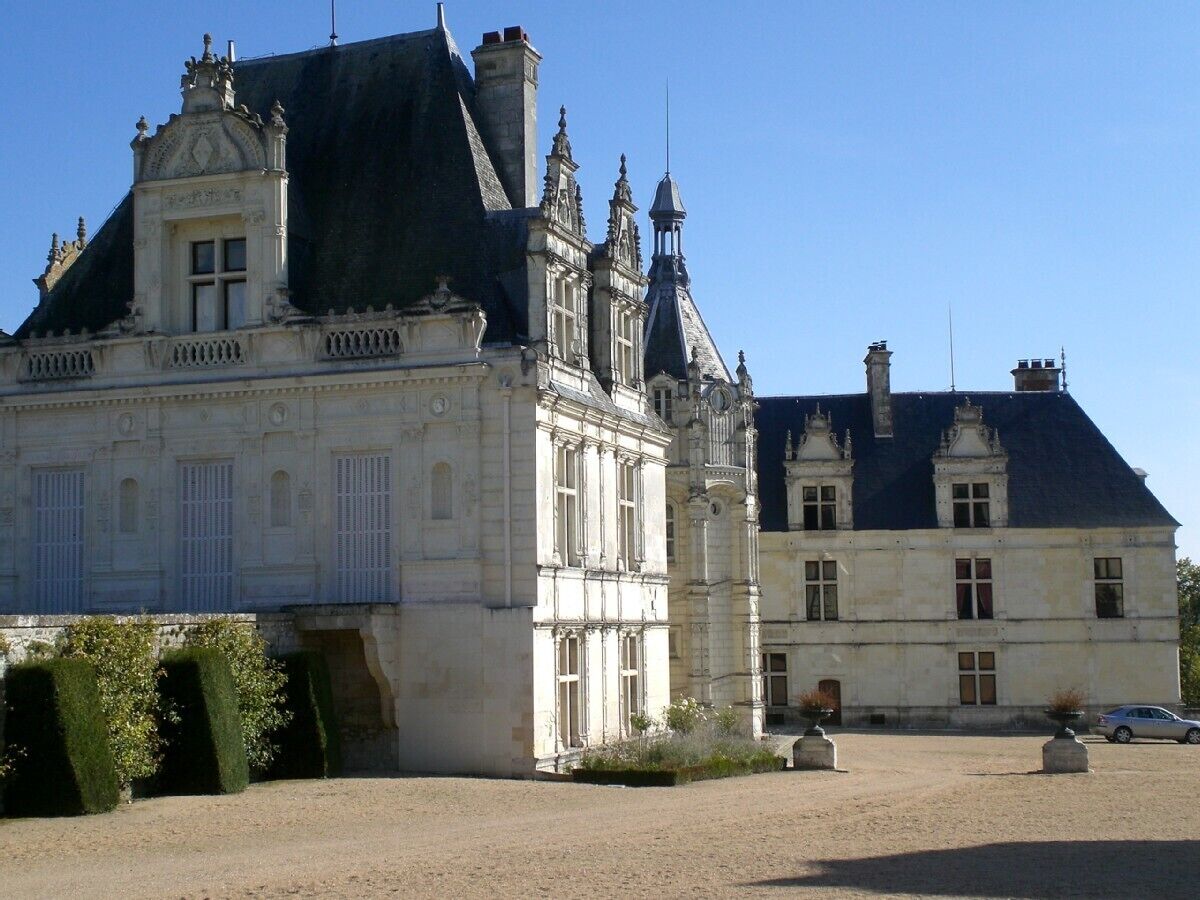Un grand bâtiment historique doté de nombreuses tours et d’une façade symétrique.