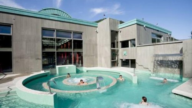 Area piscina con un edificio moderno sullo sfondo.