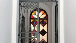 A hallway with a decorative wrought iron gate and a stained glass window. - Characteristic Apartment in the City Center of Florence (Firenze)