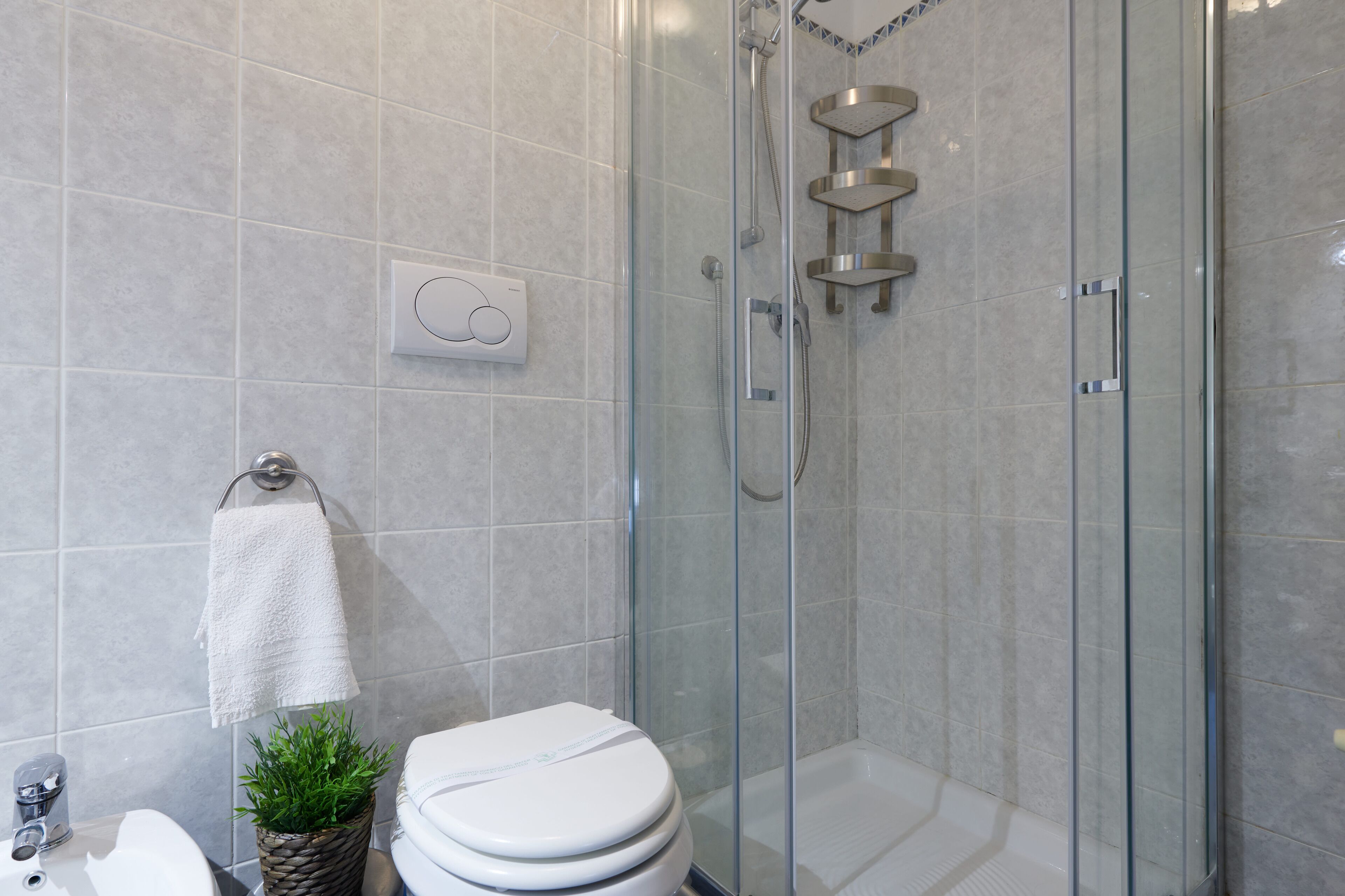 Un baño moderno con ducha envuelta en vidrio, inodoro y lavabo.
