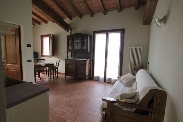 Une pièce avec un plafond en bois, une table à manger avec des chaises, un buffet et un canapé.