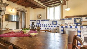 A kitchen with wooden beams, a refrigerator, a dishwasher, and a tiled backsplash. - Lovely, spacious independent apartment in Tuscan Farmhouse (Cortona)