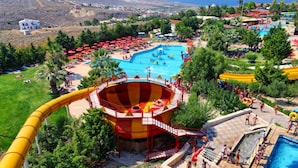 Parque acuático con una piscina grande, un tobogán de agua y una torre de salvavidas.