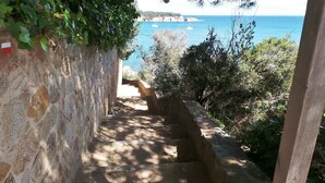 A stone staircase leading to a coastal area with boats in the background. - Except Nice. Duplex overlooking S'agaro Bay (S'agaro)