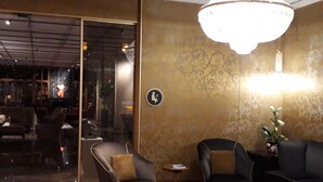 A modern lounge area with leather sofas, a glass partition, and a chandelier. - Except Nice. Duplex overlooking S'agaro Bay (S'agaro)