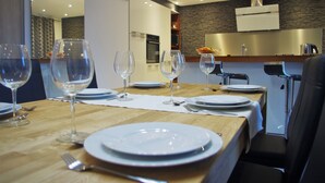 Een eethoek met een houten tafel gedekt voor een maaltijd, inclusief borden, glazen en bestek.