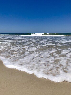 A beach with waves gently lapping onto the shore.