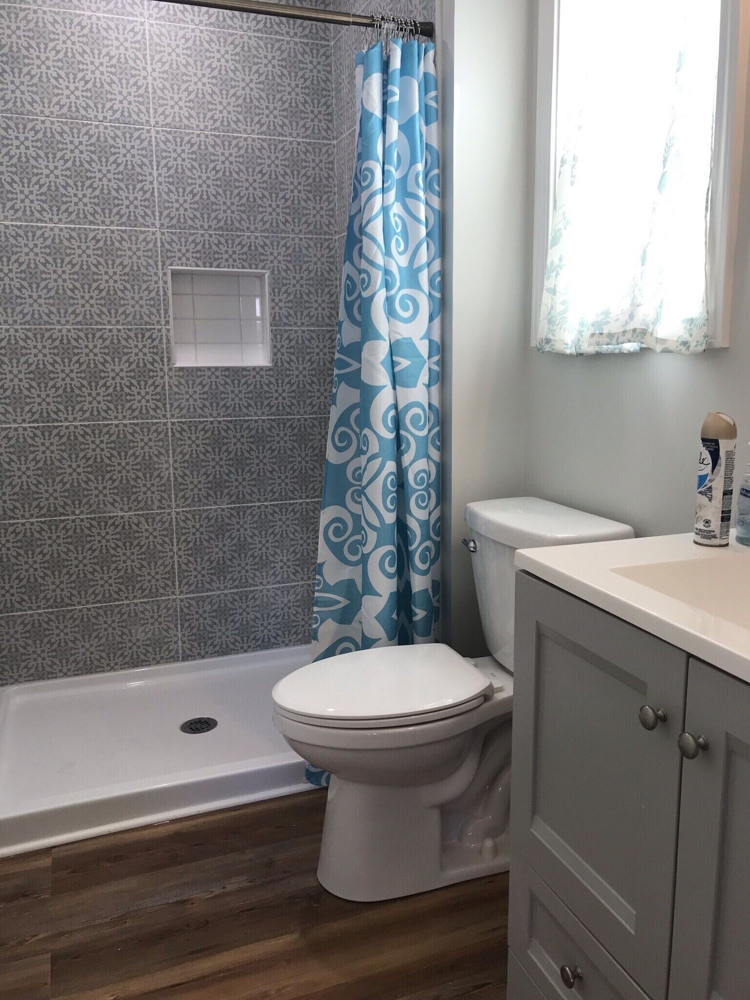 A bathroom with a shower, toilet, and vanity.