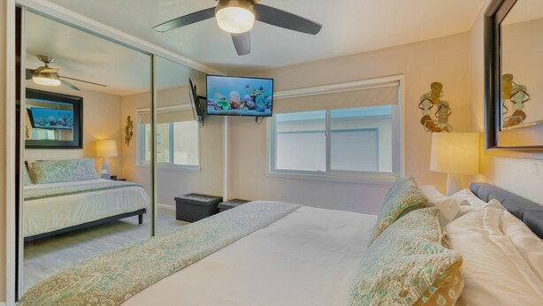 A hotel room with a bed, a ceiling fan, a TV, and a window. - Right on the Famous Mission Beach Boardwalk - Sleeps up to 10 on Ground Floor - Best location in Mission Beach (San Diego)