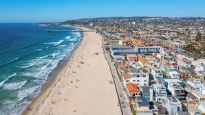 A coastal cityscape with a beach, a pier, and densely packed buildings. - Right on the Famous Mission Beach Boardwalk - Sleeps up to 10 on Ground Floor - Best location in Mission Beach (San Diego)