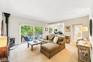 A spacious living room with a sofa, coffee table, and a fireplace.