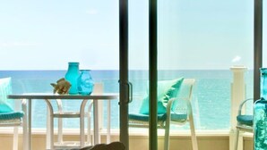 Un balcón con mesa y sillas, con vistas al mar.