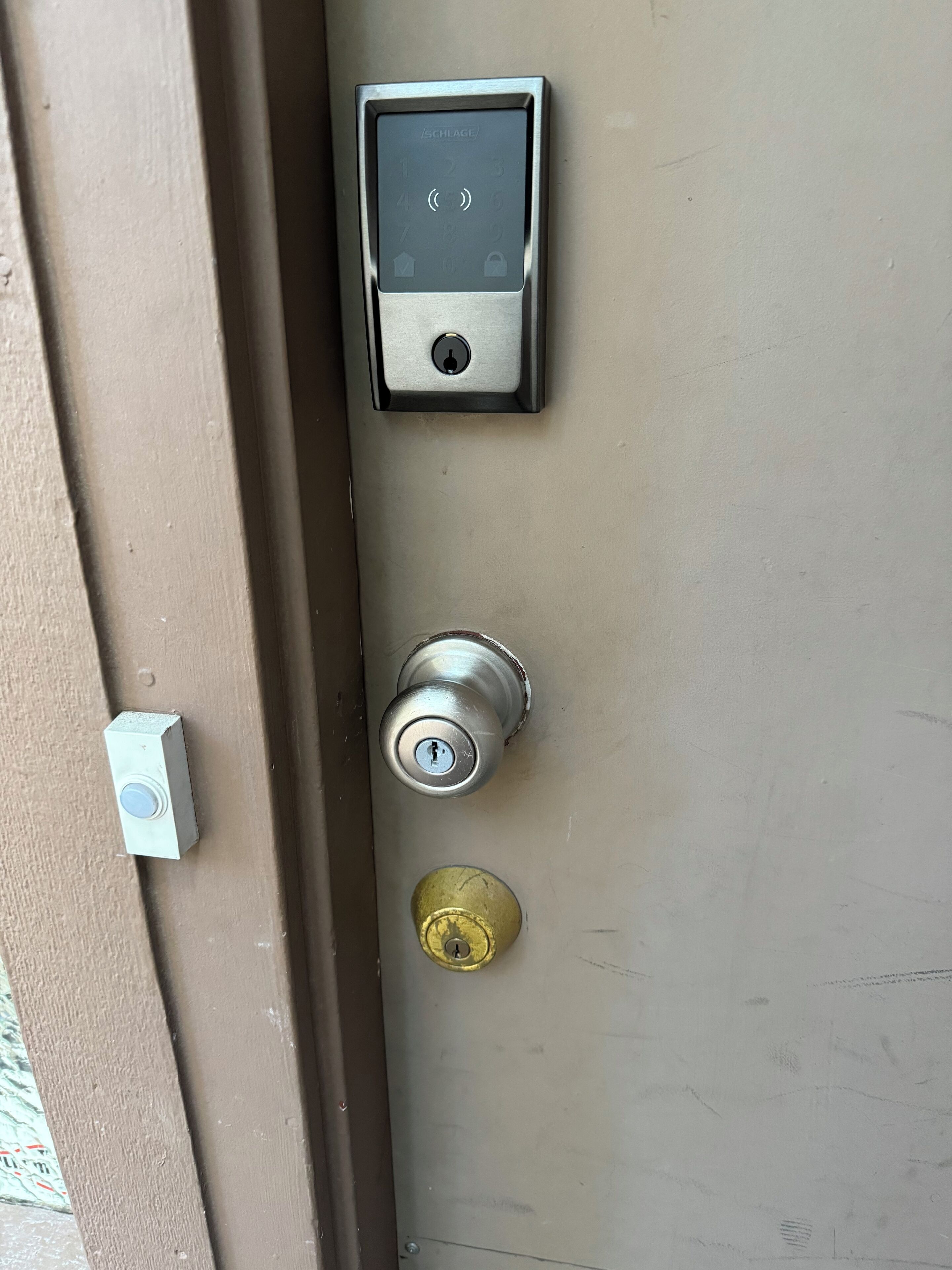A door with a digital lock, a keyhole, and a doorbell.
