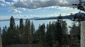 Una habitación con vistas a un lago, montañas y árboles.