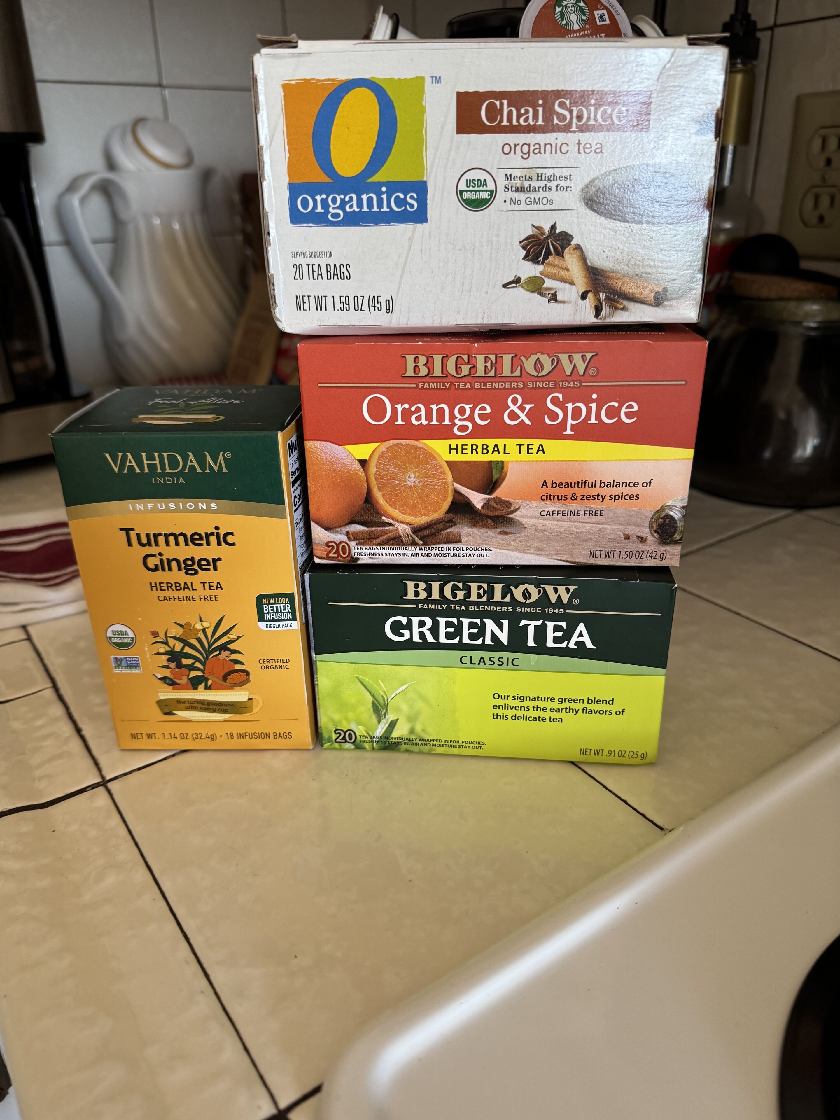 A stack of tea boxes on a kitchen counter.
