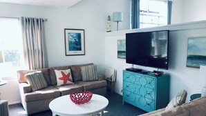 A modern living room with a sofa, a coffee table, a TV, and a cabinet. - Stunning 3BR, 2BA penthouse 5 blocks from lighthouse. Last week open 8/16-23! (Barnegat Light)