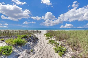 A sandy beach path leading to the ocean with a wooden fence and sparse vegetation. - 100 Steps to the Gulf -Soaring Ceilings, Beams, Contemp, Free Lighthouse Passes (Saint George Island)