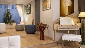 A living room with a grand piano, a potted plant, and a bench.
