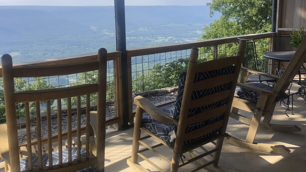 Un ponte di legno con vista sul mare, una sedia e un tavolo.