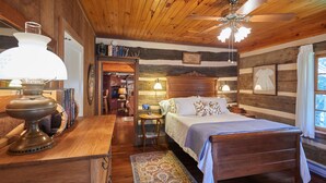 Un dormitorio acogedor con una cama de madera, una mesita de noche, una lámpara y una alfombra.