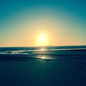 A beach with the sun setting over the ocean. - Beverly beach delight (Newport)