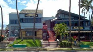 Un edificio con un letrero que indica 'Moose McGillicuddy Pub & Cafe' y otro para 'Hawaiian Cafe'.