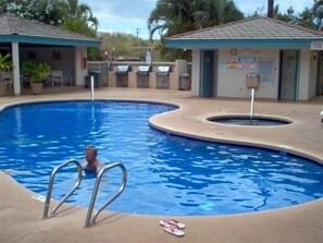 Relax by the pool surrounded by lush greenery and comfortable outdoor seating.