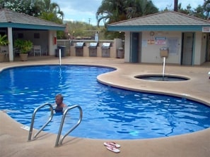 Relax by the pool surrounded by lush greenery and comfortable outdoor seating.