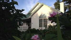 Une maison avec un toit végétalisé, une véranda et une grande fenêtre.