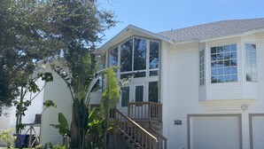 Une maison à deux étages avec un porche à l’avant, un escalier et un garage.