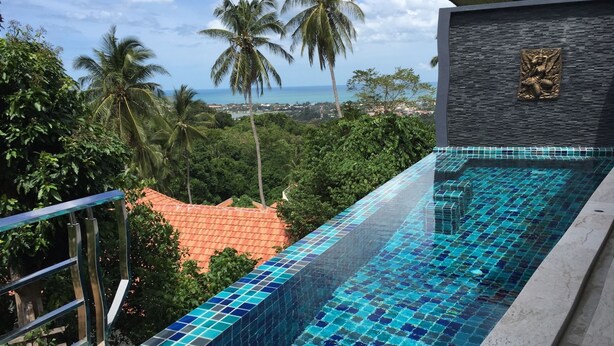 A swimming pool with blue mosaic tiles, surrounded by greenery and a view of the ocean. - 3 Bedroom Sea View Villa 2 - Chaweng Noi SDV162-By Samui Dream Villas (Koh Samui)