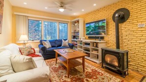 A cozy living room with a fireplace, a sofa, a coffee table, and a TV.