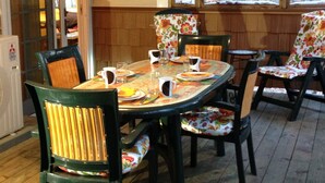 A dining area with a round table set for four, surrounded by chairs with floral upholstery.